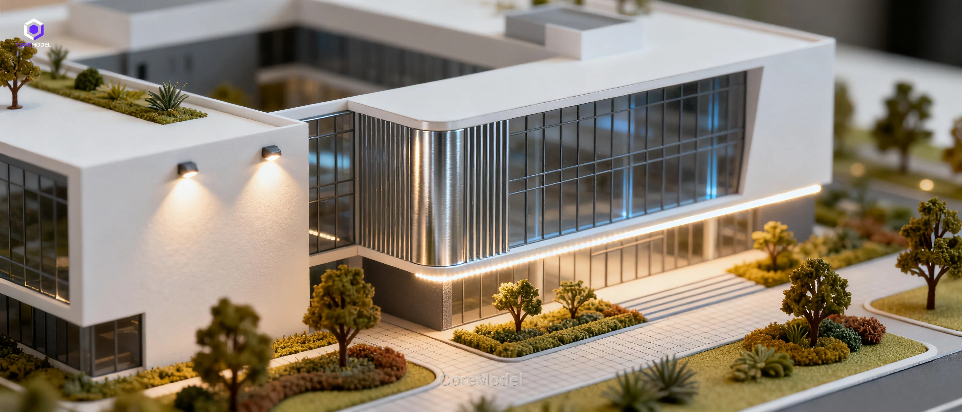 Professional architectural scale model of a modern building complex with detailed landscaping and lighting